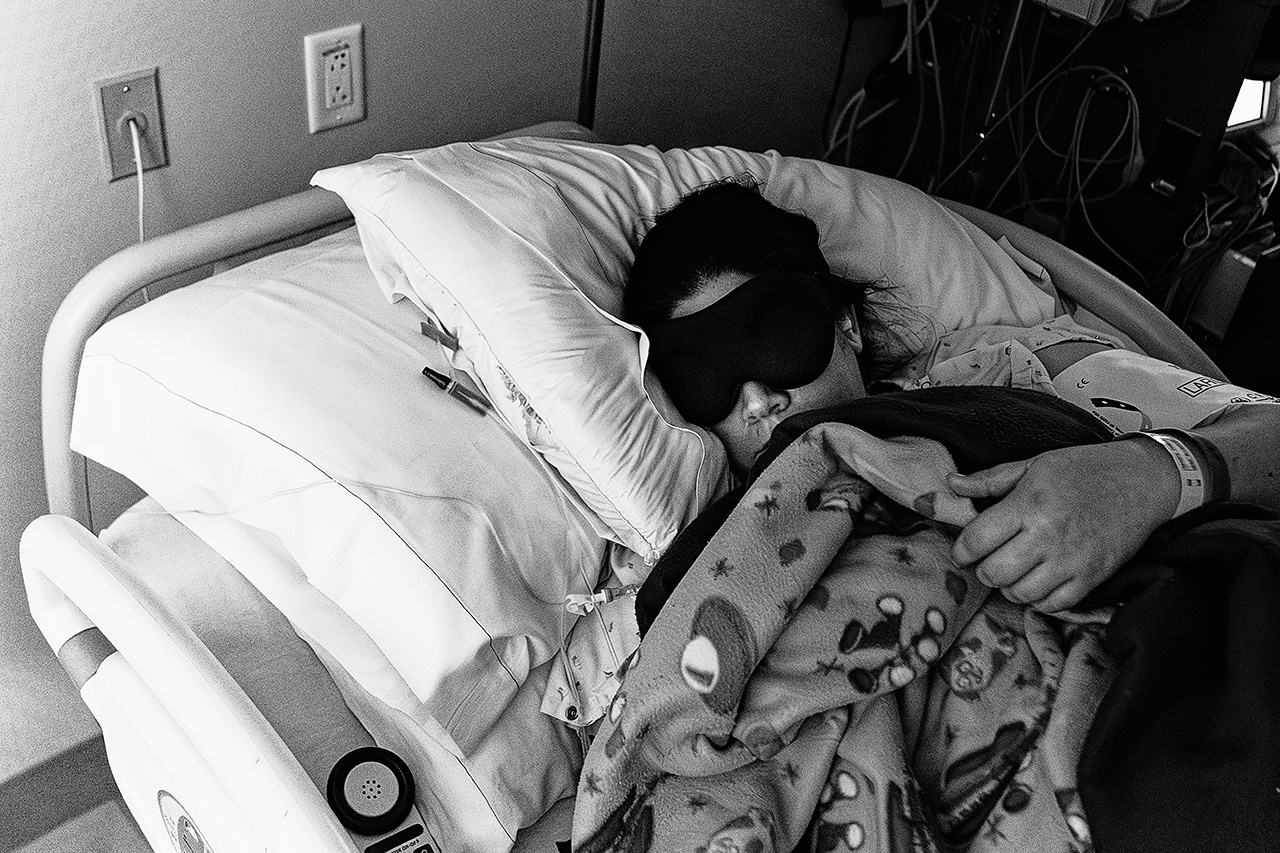 Black and white birth photo of a mother finally getting some sleep after having an epidural. Photo by Birth and Beauty