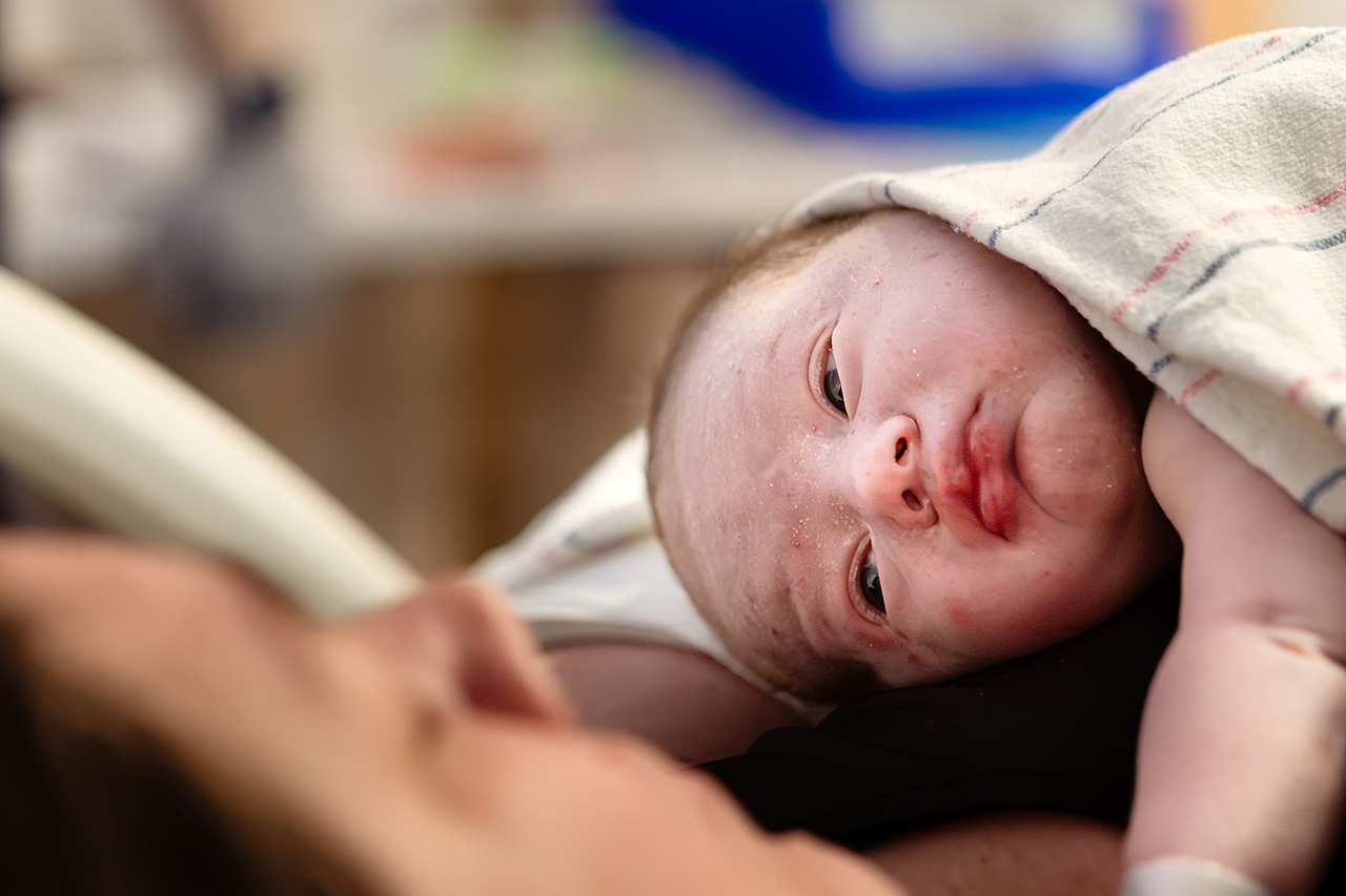 Birth photo of a newborn boy's face by Leona Darnell.