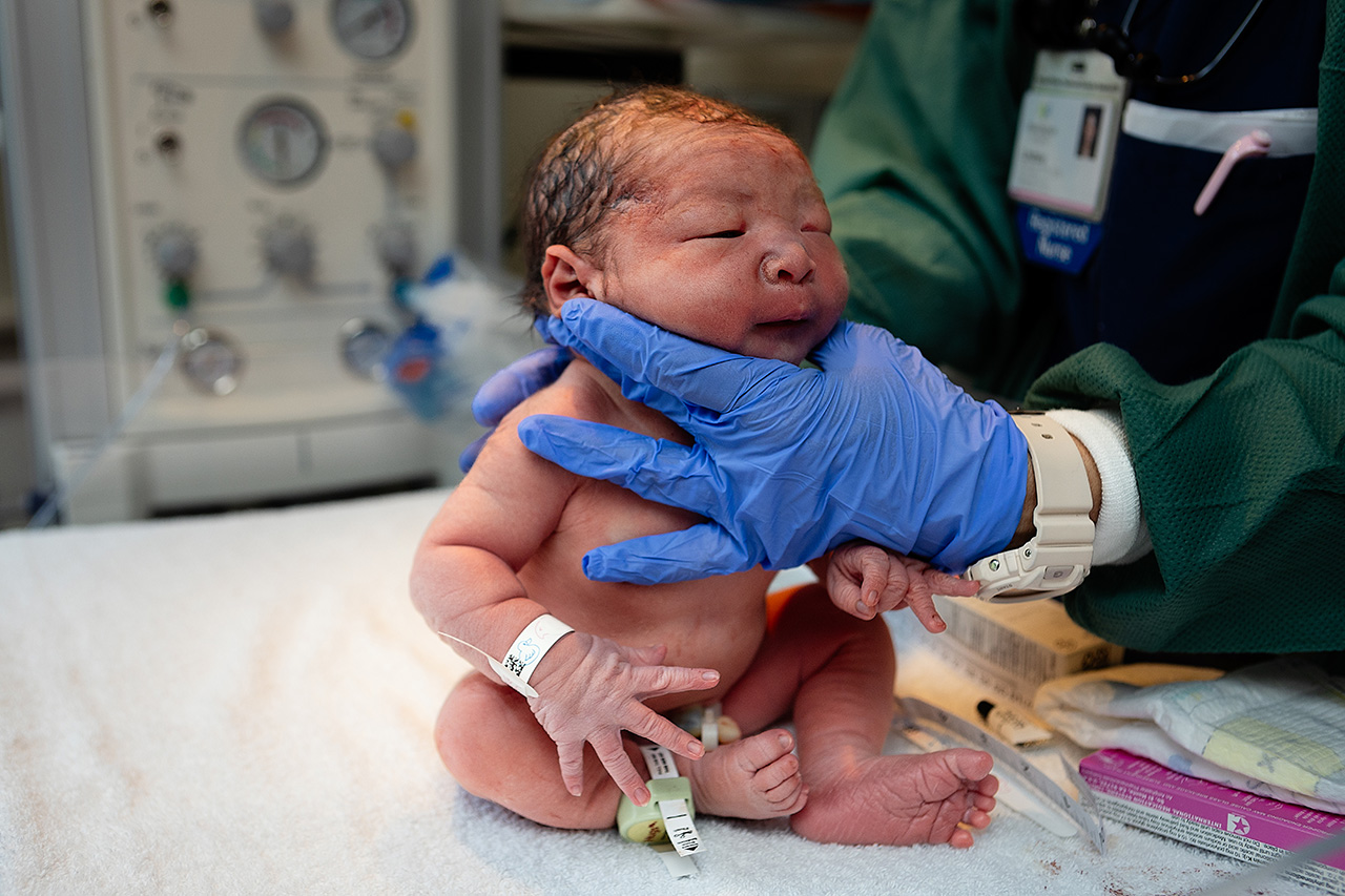 Newborn baby exam photo by Los Angeles birth photographer Leona Darnell.